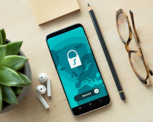 Smartphone mit Sicherheitssymbol auf einem Schreibtisch